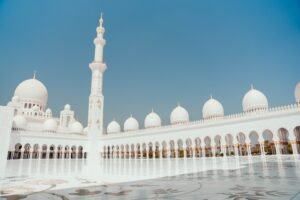 Sheikh Zayed Mosque's white domes and minaret under a clear sky